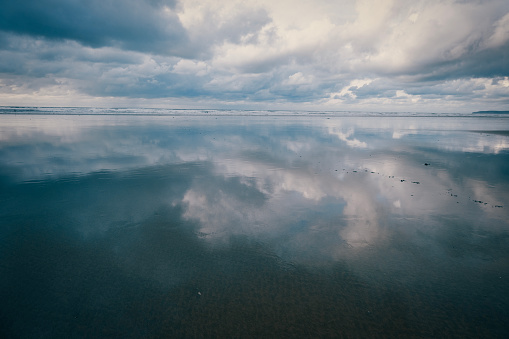 Sea and sky captured in the retreating tide on a beach in Devon