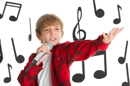 Teen boy singing with musical notes background