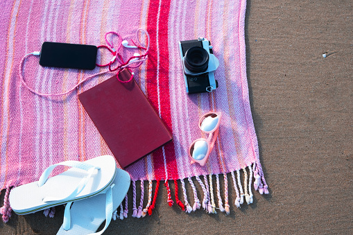 Camera, mobile phone, flip flops and a book for a day on the beach