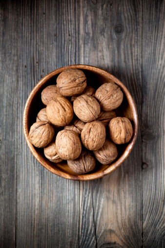 Bowl of walnuts on wooden table