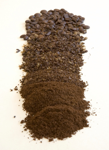 coffee beans and coffee grounds at varying stages of grinding