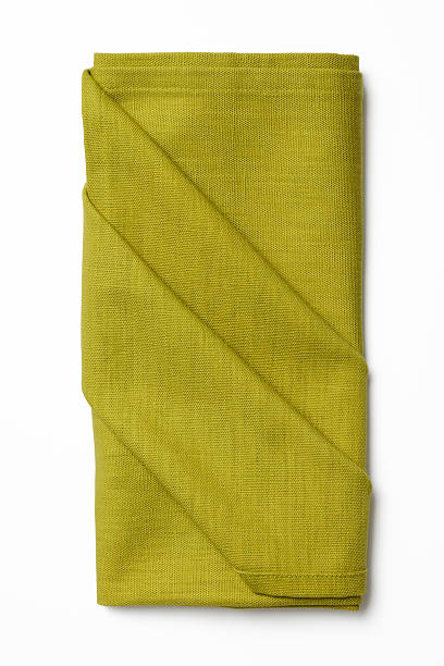 Folded green napkin isolated on white background with shadow.