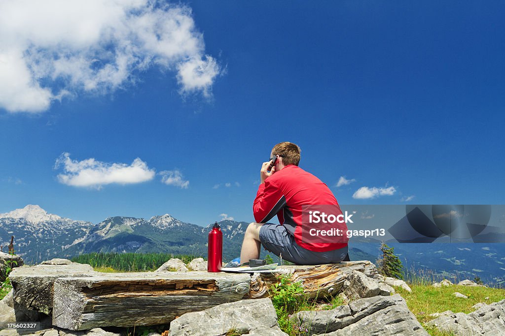 Jovem usando telefone celular nas montanhas - Foto de stock de Longa Caminhada royalty-free