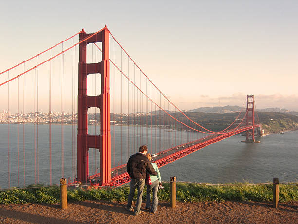 golden gate bridge con una pareja admira la vista. - golden gate bridge san francisco county san francisco bay bay fotografías e imágenes de stock