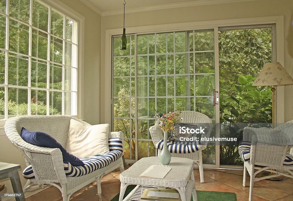 Cozy sunroom interior view from sunroom with white wicker furniture Conservatory - Sun Room Stock Photo
