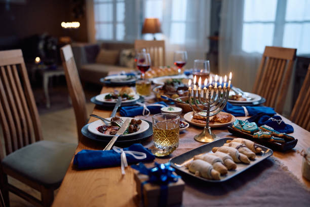 istock Lit menorah on dining table prepared for family meal on Hanukkah. 1756041616