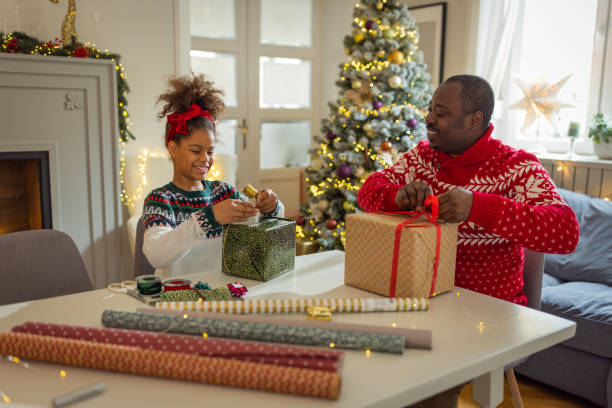 istock Father and daughter wrapping Christmas gifts 1756045232