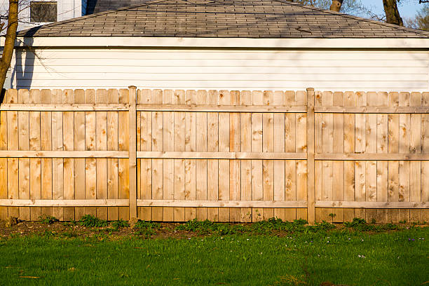A hard wood fence outside a house tall brown wooden property fence fence stock pictures, royalty-free photos & images