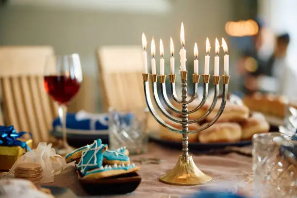 Menorah with lit candles on the table during Hanukkah.