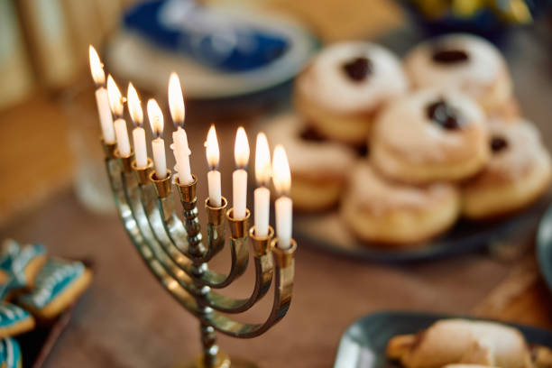 istock Menorah with lit candles on the table during Hanukkah. 1756049938