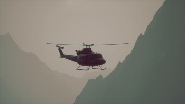 A helicopter flying over a mountain with a sky background