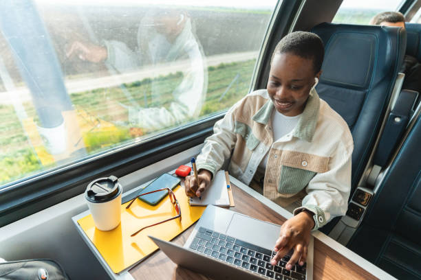 istock African-American woman using laptop on public transport returning from work. 1756059461