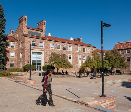 Boulder, Colorado, USA-October 23, 2023: African American student walking between buildings on the campus of the University of Colorado, Boulder.