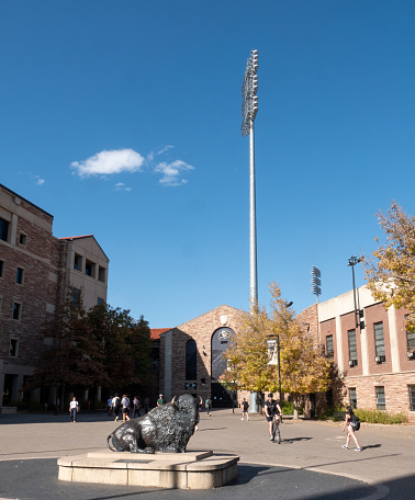 Boulder, Colorado, USA-October 23, 2023: Students walking and riding between classes in a plaza next to Folsom Field on the campus of the University of Colorado, Boulder.