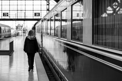 Germany, Leipzig, October 08, 2023 - Rear view of woman walking at railroad station platform