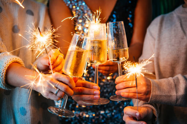 Christmas Friends celebrating Christmas or New Year's eve with Bengal lights and champagne. toasting stock pictures, royalty-free photos & images