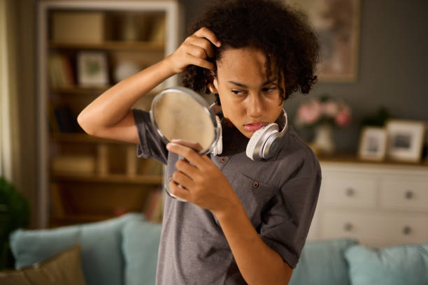 istock Teenage boy with acne problem looking in mirror at home 1756090572