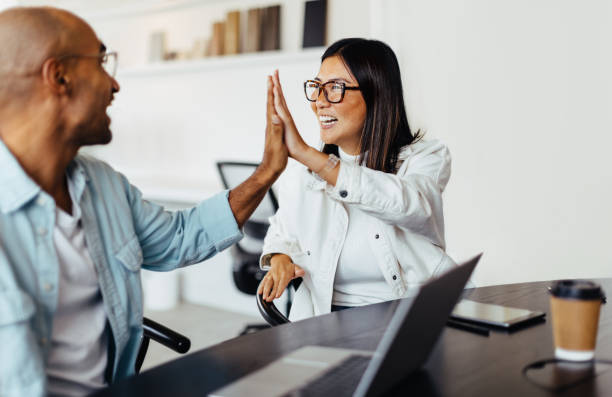 istock Business people giving each other a high five in an office 1756092249