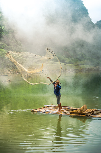 view of fishermen fishing on river in Thung mountain in Tra Linh, Cao Bang province, Vietnam with lake, cloudy, nature. Travel and landscape concept.