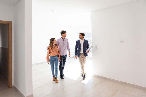 Argentinean real estate agent and young heterosexual couple happy at their new home - Buenos Aires - Argentina