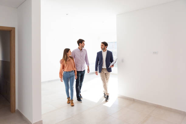 Real estate agent and young couple in new home stock photo