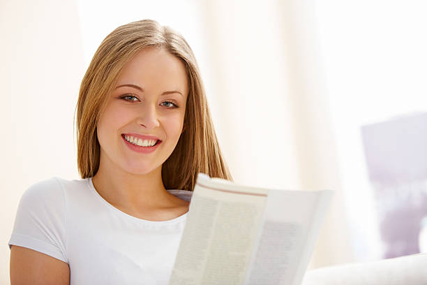 istock Pretty young woman reading a magazine 175613359
