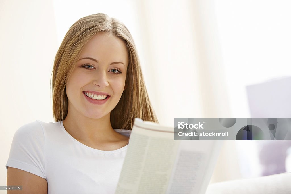 Довольно Молодая женщина, читать журнал - Стоковые фото 18-19 лет роялти-фри
