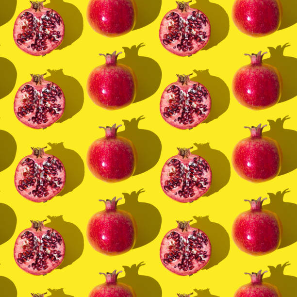 istock Trendy fruit pattern made of fresh red pomegranates on light yellow background. Minimal healthy food layout. Nature fruit concept. Pomegranate aesthetic background pattern. 1756138748