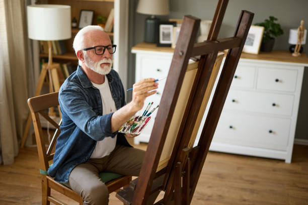 istock Elderly man painting on a canvas at home 1756139884