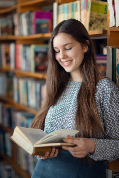 istock High school female student reading book in library 1756144370