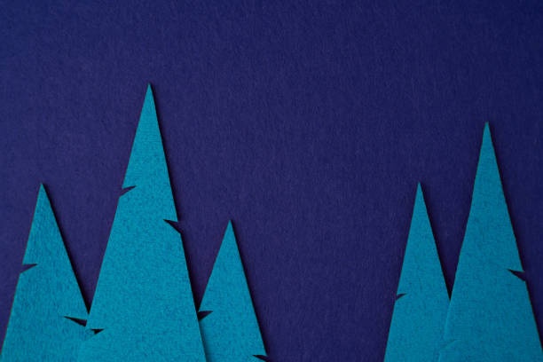 istock Creative Christmas tree shapes from blue textiles on a bright festive blue background. Imitation of the atmosphere of the night. Simple Christmas or New Year concept with space for text 1756145515