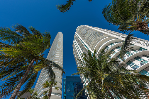Wide angle view up towards the sky of Downtown Miami and its ultra modern contemporary buildings with unique architecture.