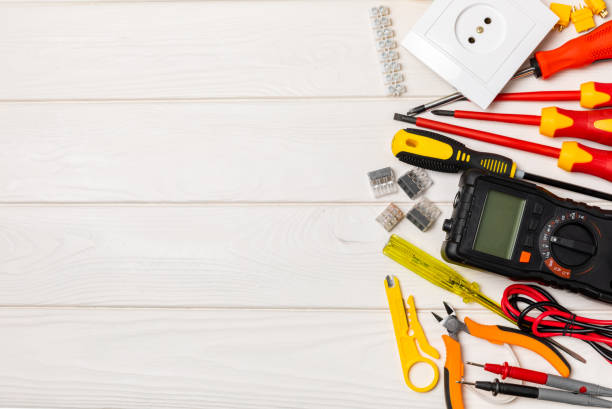 istock Electrician tools on background. Multimeter,construction tape,electrical tape, screwdrivers,pliers,an automatic insulation stripper, socket and LED lamp. Flatley. electrician concept. 1756153073