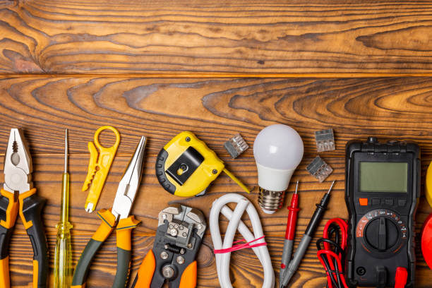 istock Electrician tools on background. Multimeter,construction tape,electrical tape, screwdrivers,pliers,an automatic insulation stripper, socket and LED lamp. Flatley. electrician concept. 1756153598