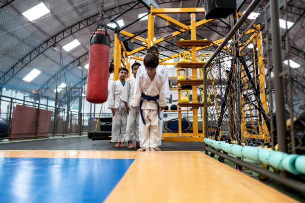 chłopiec kłania się przed wejściem na zajęcia judo na siłowni - respect karate bowing martial arts zdjęcia i obrazy z banku zdjęć