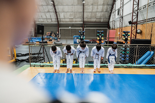 Students bowing in a judo class at the gym