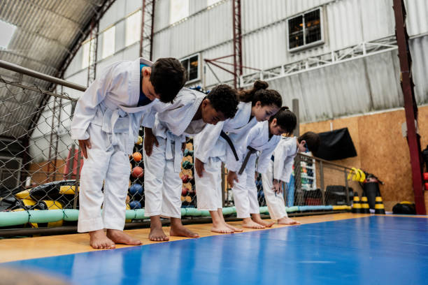 uczniowie kłaniają się na zajęciach judo na sali gimnastycznej - respect karate bowing martial arts zdjęcia i obrazy z banku zdjęć