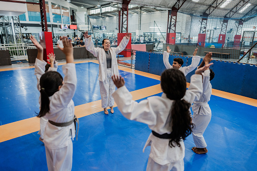 Sensei and students stretching in a judo class at the gym