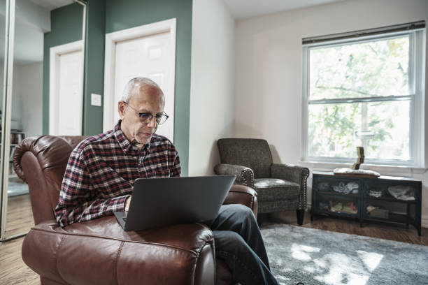 istock Senior man using laptop in his living room 1756188960