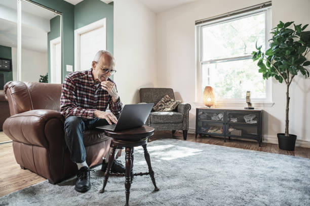 istock Senior man using laptop in his living room 1756188963