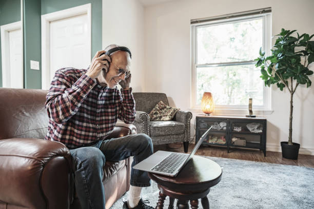 istock Senior man using laptop in his living room 1756189465