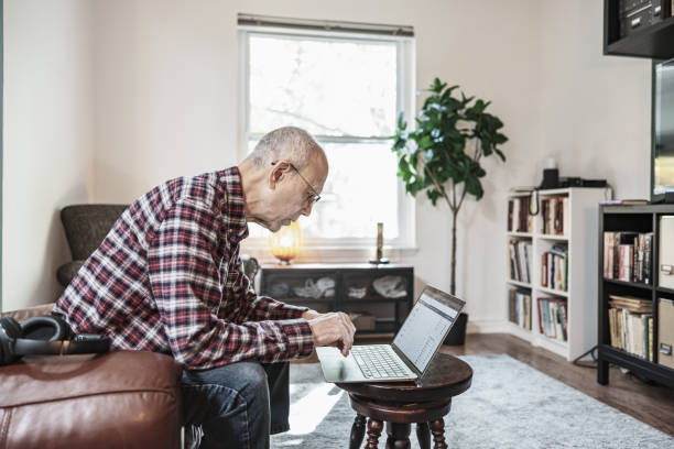 istock Senior man using laptop in his living room 1756189476