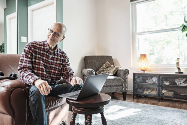 istock Senior man using laptop in his living room 1756189486