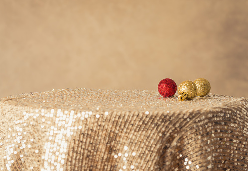 Gold sequins scales background, party table copy space, display product mock up table with gold sparkly table cloth, Christmas background.