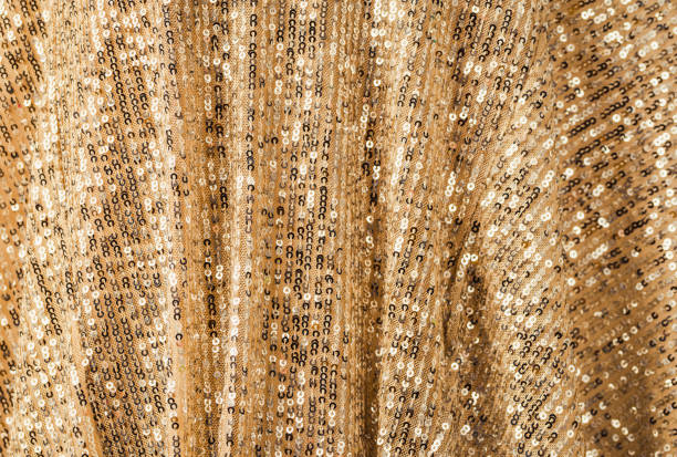 Gold glittering sequins scales background, fabric with sequins party background glittery texture .