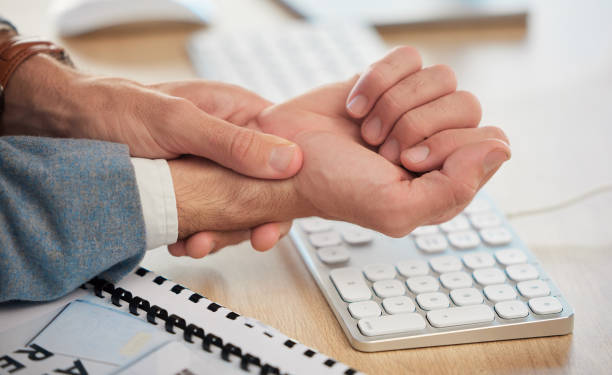 Hands, office or businessman with wrist pain while working on a computer workplace with arthritis or injury. Hurt hand, carpal tunnel emergency or closeup of injured worker with discomfort arm cramp