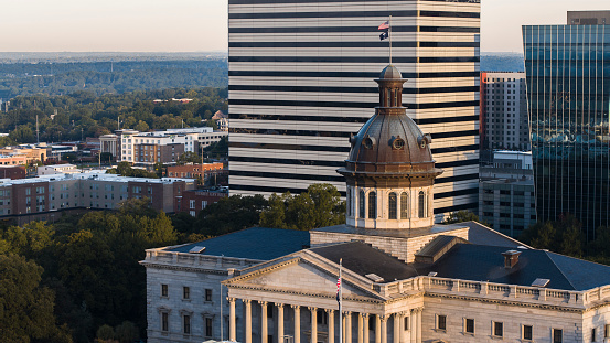 In the early light, the South Carolina State House faces off with the skyscrapers and apartments of Downtown Columbia, SC.
