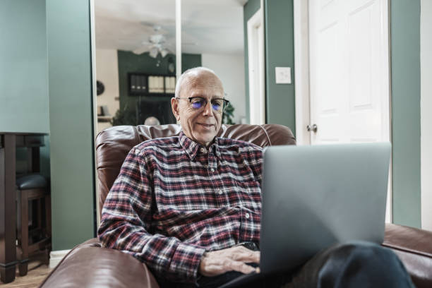 istock Senior man using laptop in his living room 1756204481