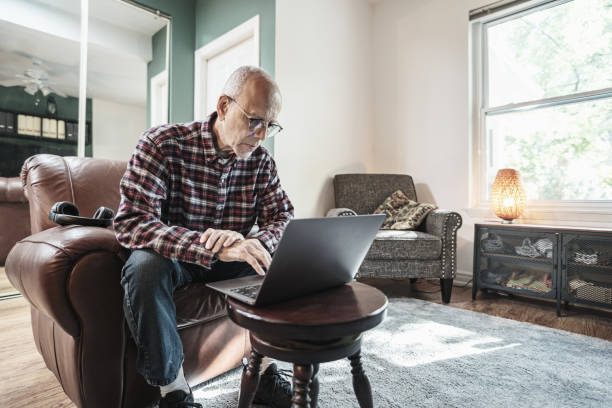 istock Senior man using laptop in his living room 1756205058