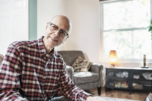 istock Senior man using laptop in his living room 1756205074